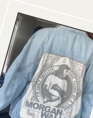 A denim jacket with a large printed back panel