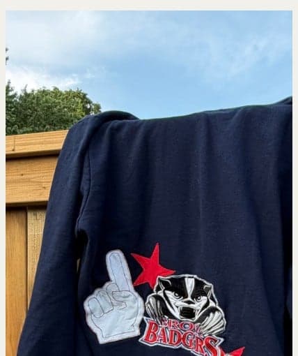 A Badgers crewneck with a foam finger and the number 32