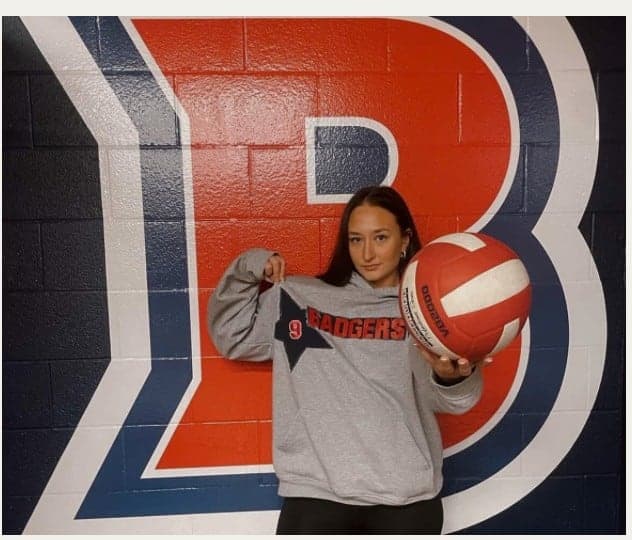 A grey Badgers crewneck worn with a volleyball in front of the Brock B