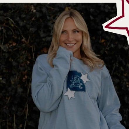 A pale blue crewneck with a denim patch and stars