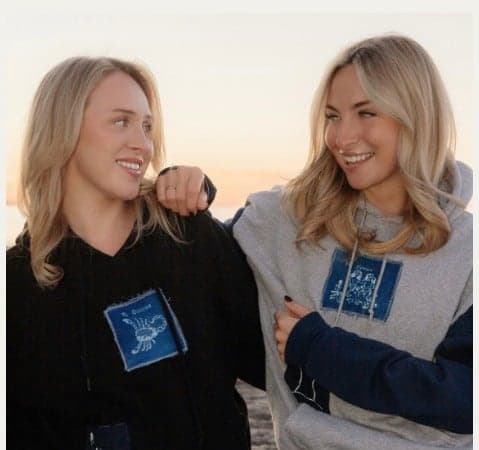 Two patchwork crewnecks, one black and one grey, worn at sunset